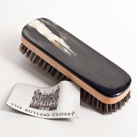 Natural English Oxhorn Clothes Brush With A Logo For The Butler's Closet On A Tag Beside It