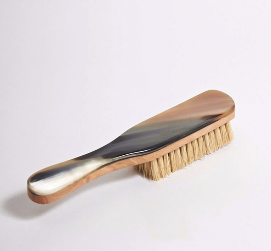 Wooden-handled clothes brush with natural bristles on a white background