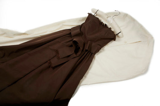 Brown evening gown laid over a white garment cover with a hanger