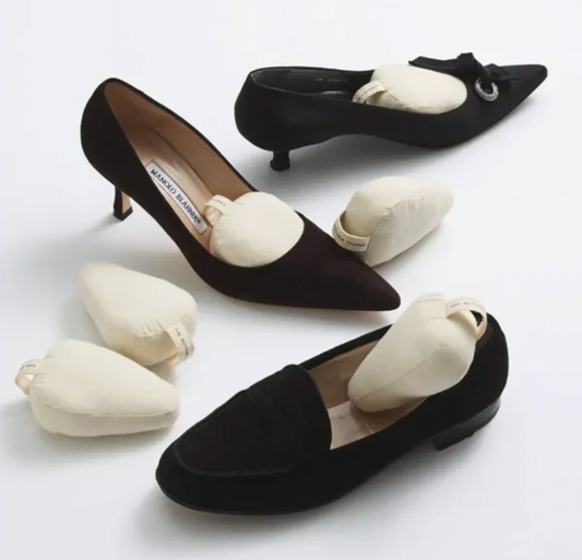 Cream-Colored Cotton Shoe Shapers Inside and Beside Black Dress Shoes