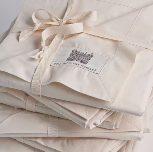 Folded fabric sofa covers tied with ribbon, highlighting material quality and stitched label