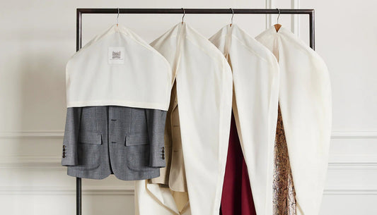 Garments protected in breathable closet covers on a clothing rack