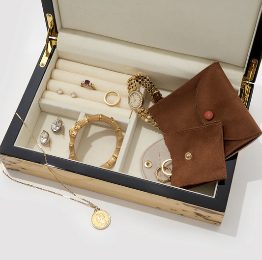 Jewelry box with gold accessories and brown travel jewelry pouches
