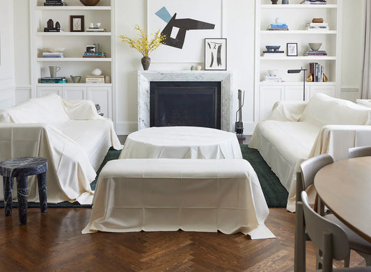 Living room furniture covered with white protective dust covers
