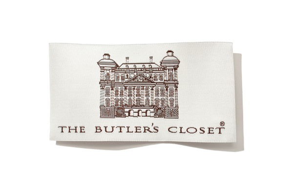 Image of a folded white napkin with a printed architectural design and text THE BUTLER'S CLOSET.
