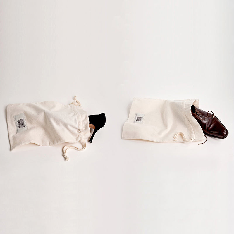 Two Luxury Travel Shoe Bags. One With A Woman's Shoe And One With A Man's Shoe Sticking Out.