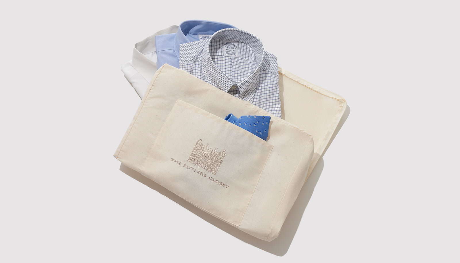 Cotton Storage Bag For Garments With Three Shirts And A Tie Sticking Out Of It